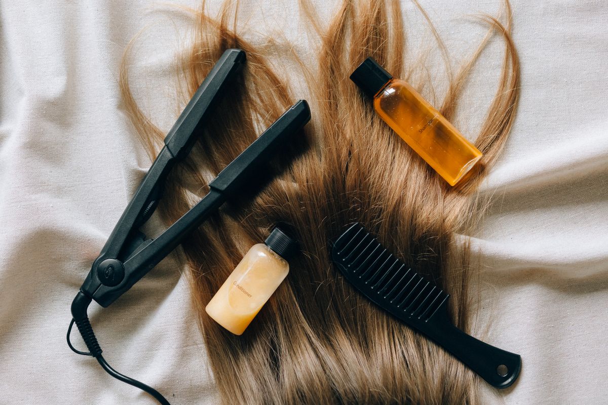 Hair care bottles and a comb arranged on a bathroom counter