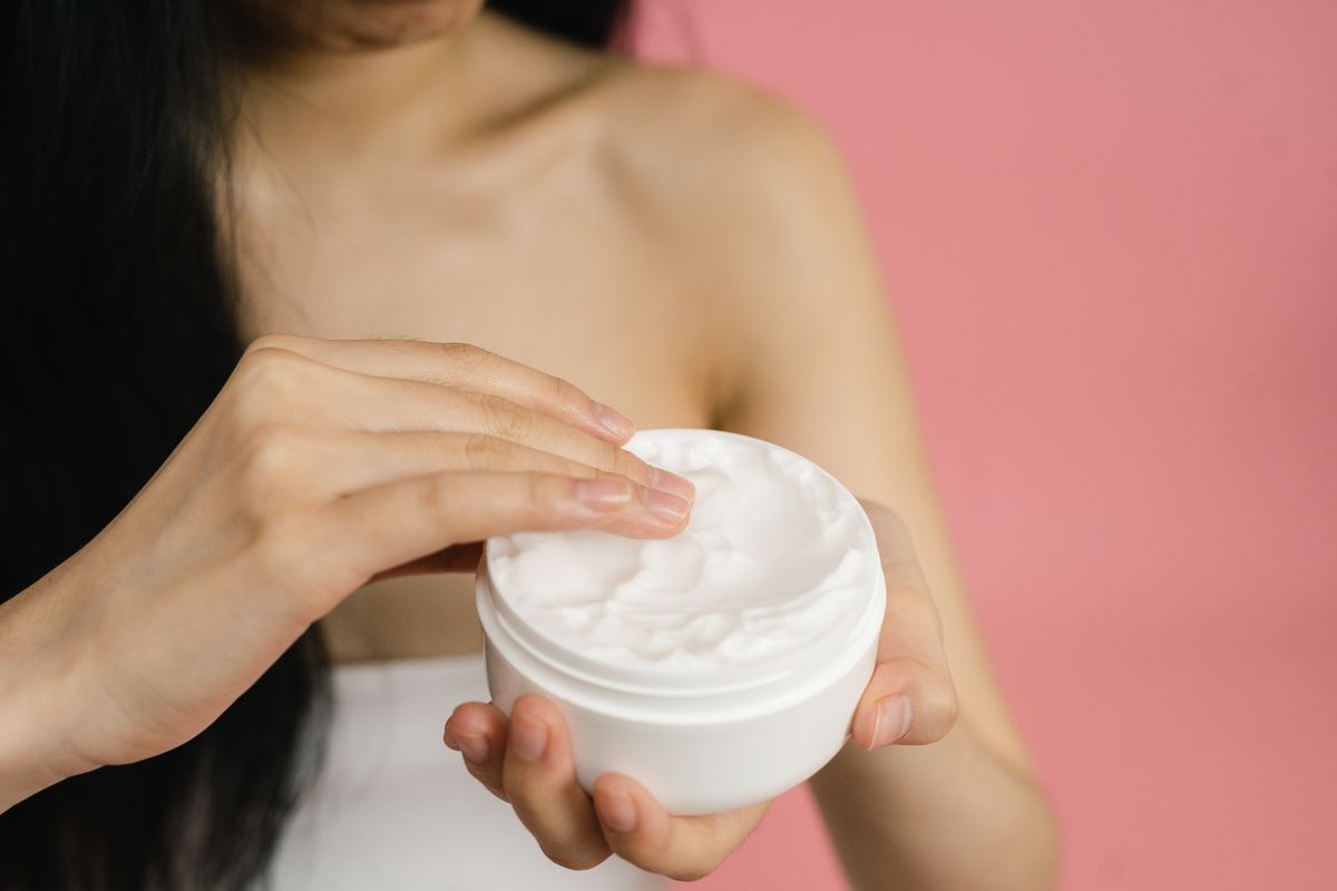 Woman dabbing cream around her eye area with a fingertip