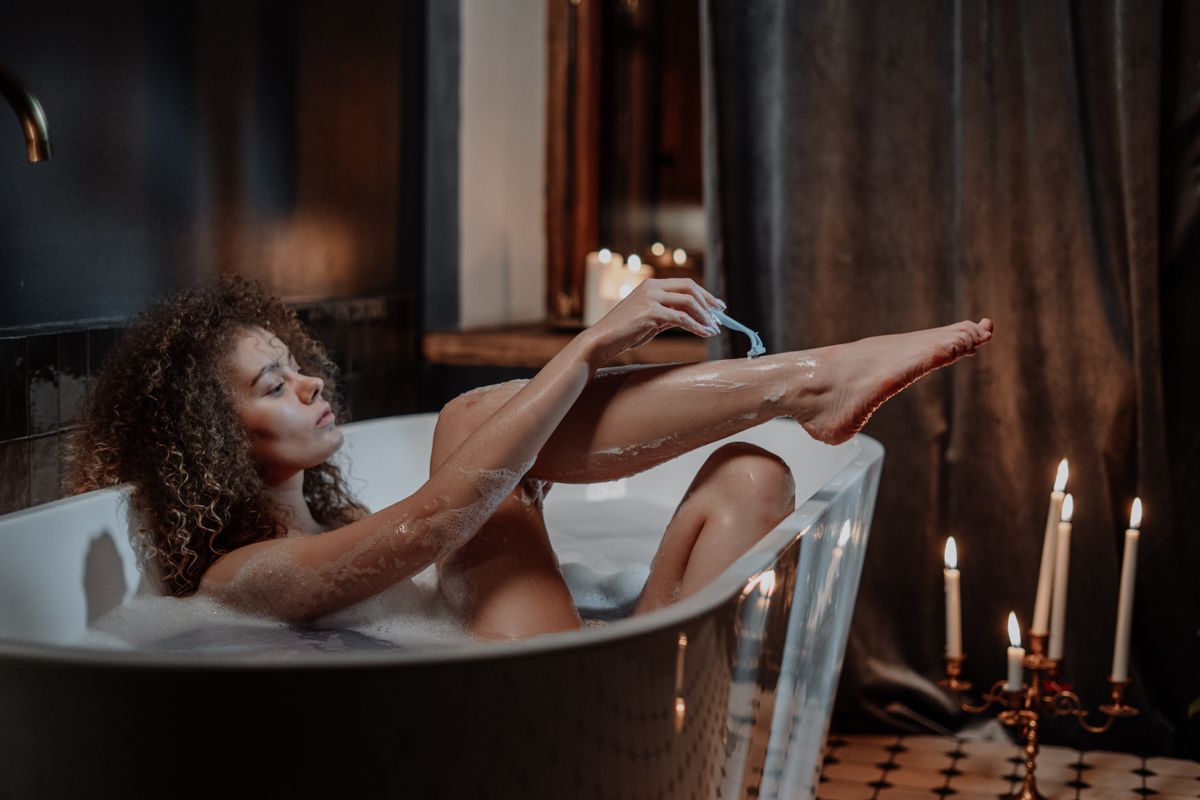 A woman washing her hair with water running