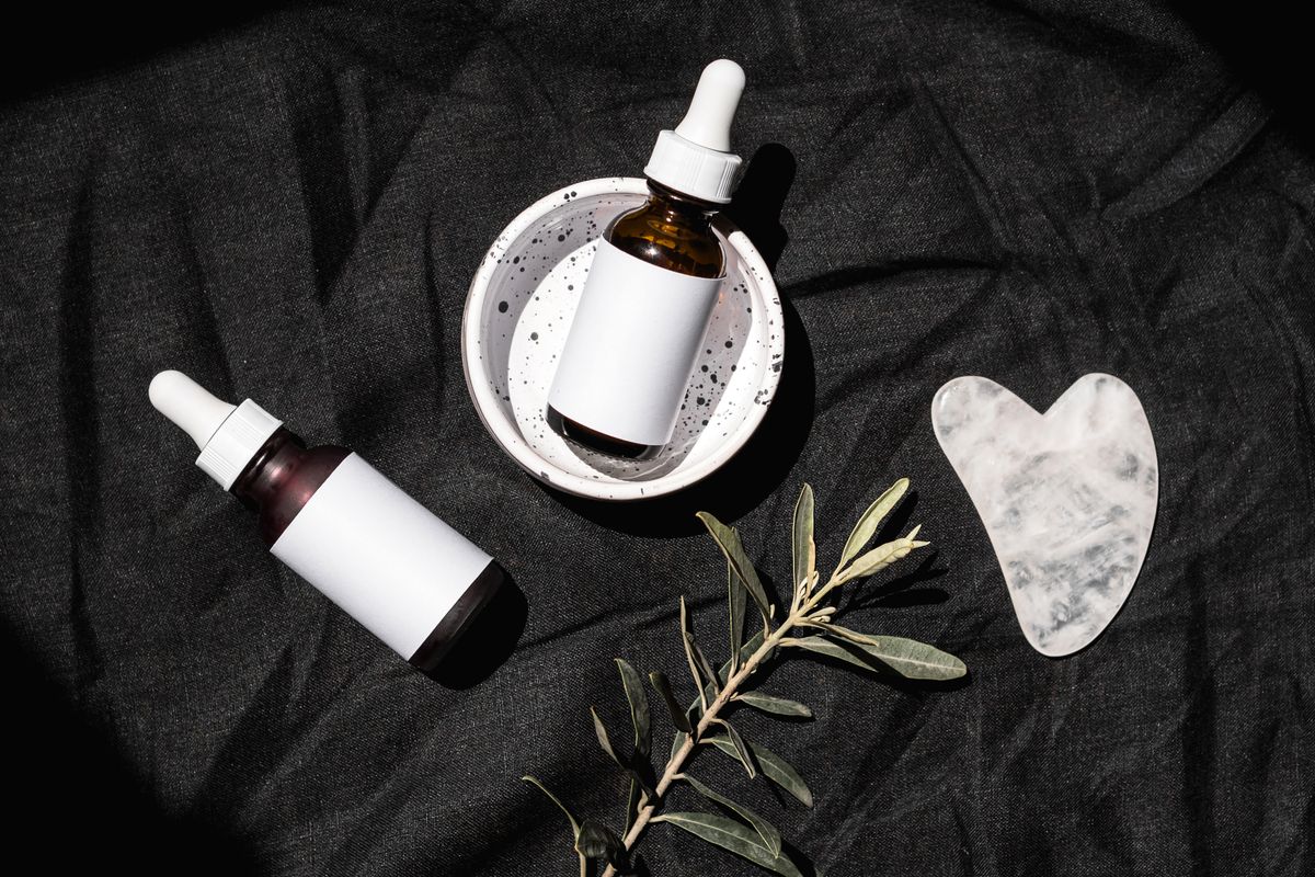 Unlabeled white and brown serum bottles arranged on white fabric