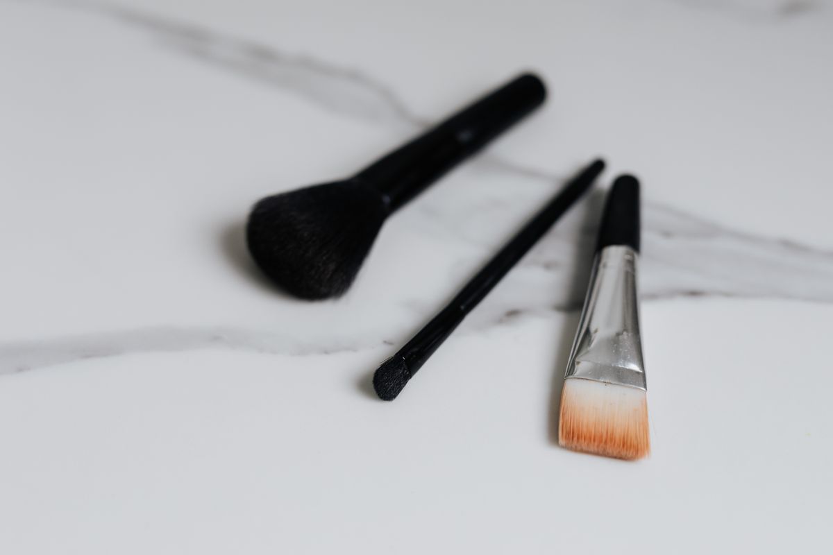 A row of clean makeup brushes on a white surface