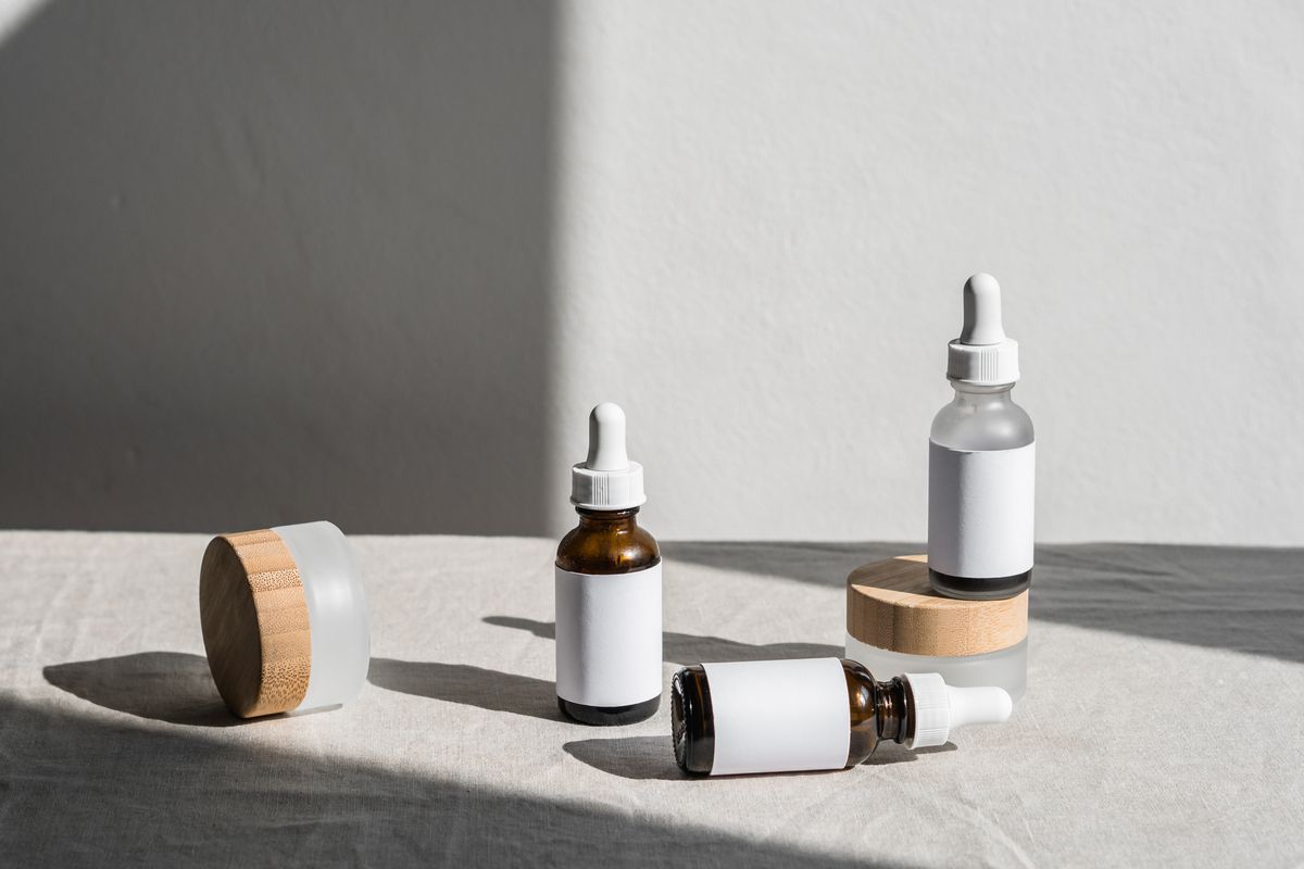 Row of retinol serum bottles with droppers on a neutral bathroom shelf