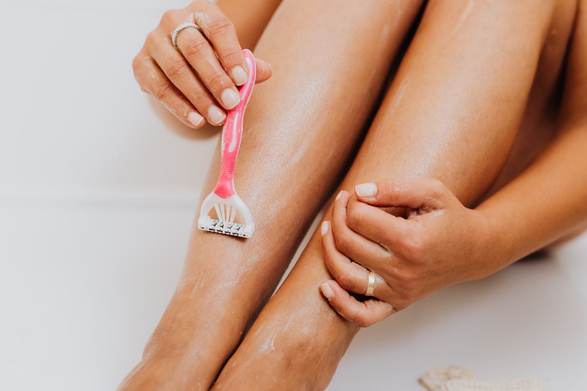 A razor gliding over a leg with shaving foam